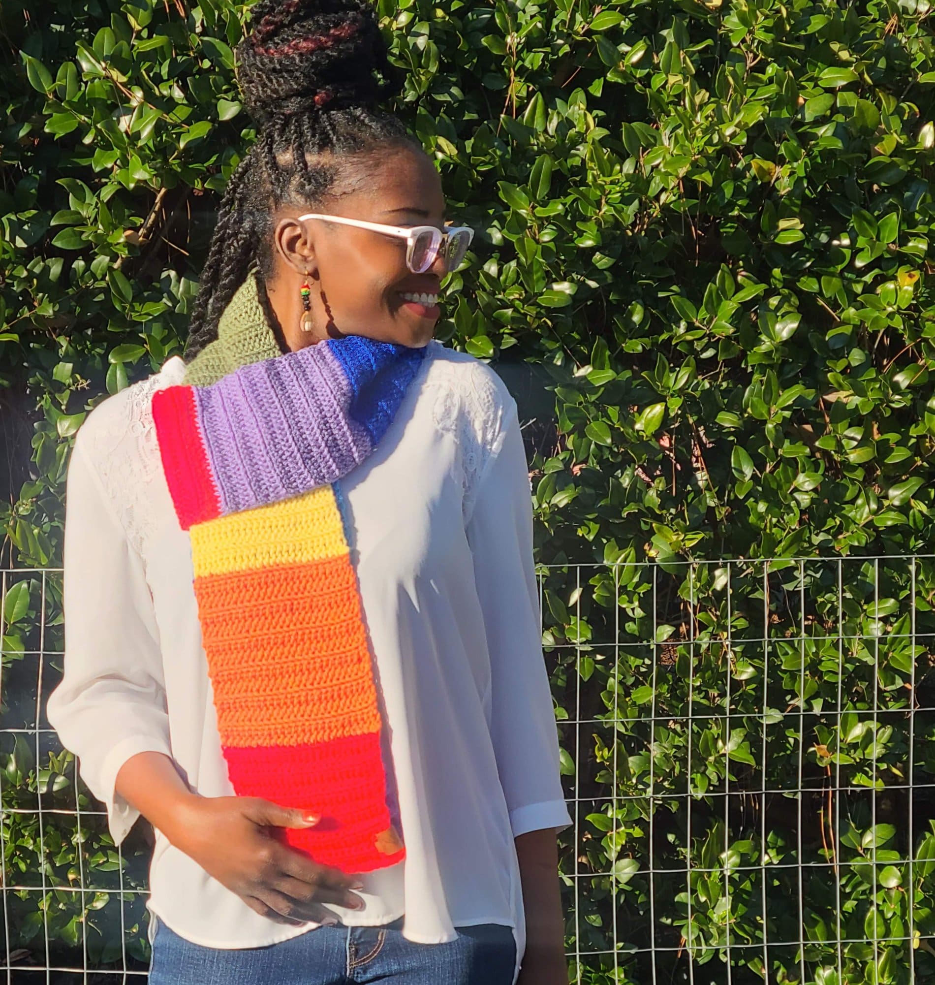 Model wearing rainbow colored winter scarf