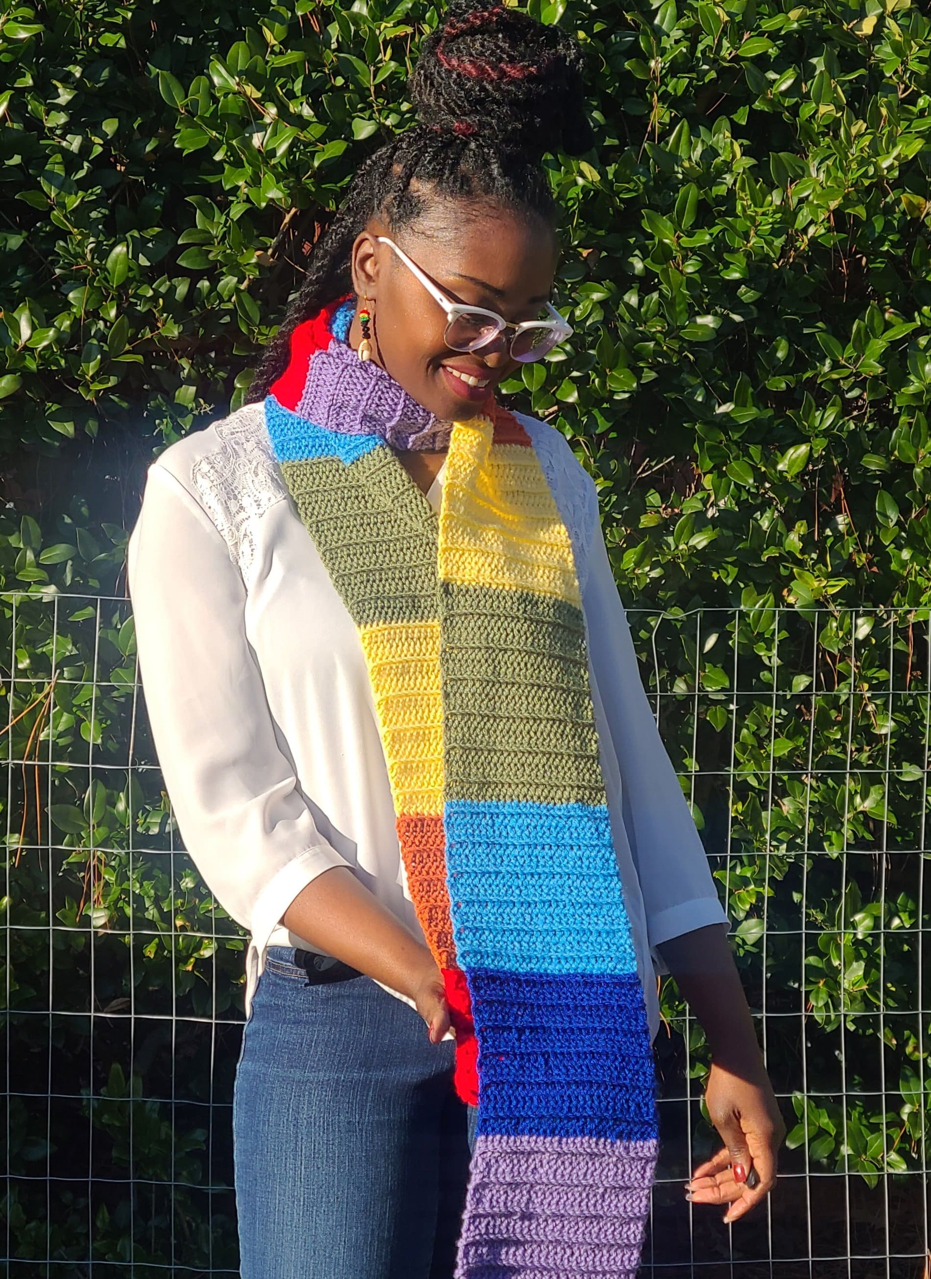Rainbow colored winter scarf with model wearing it