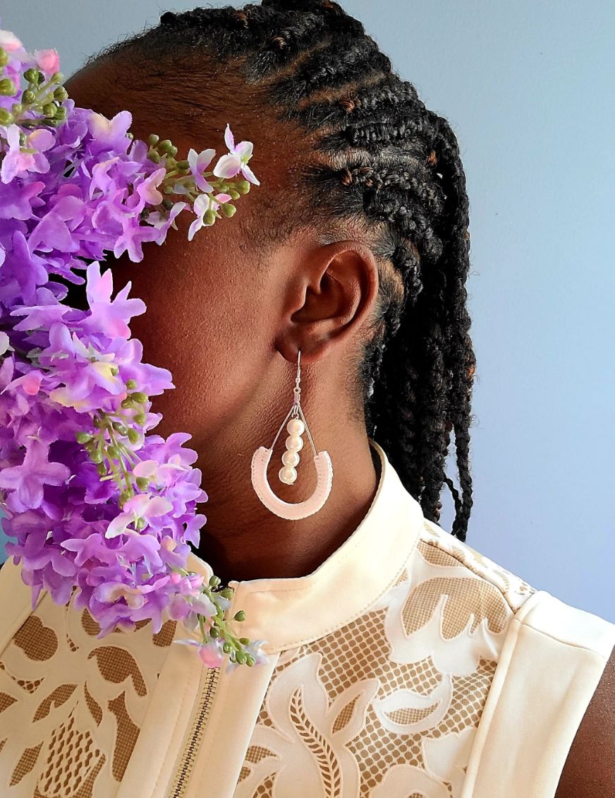 Model wearing pearl dangle earrings.