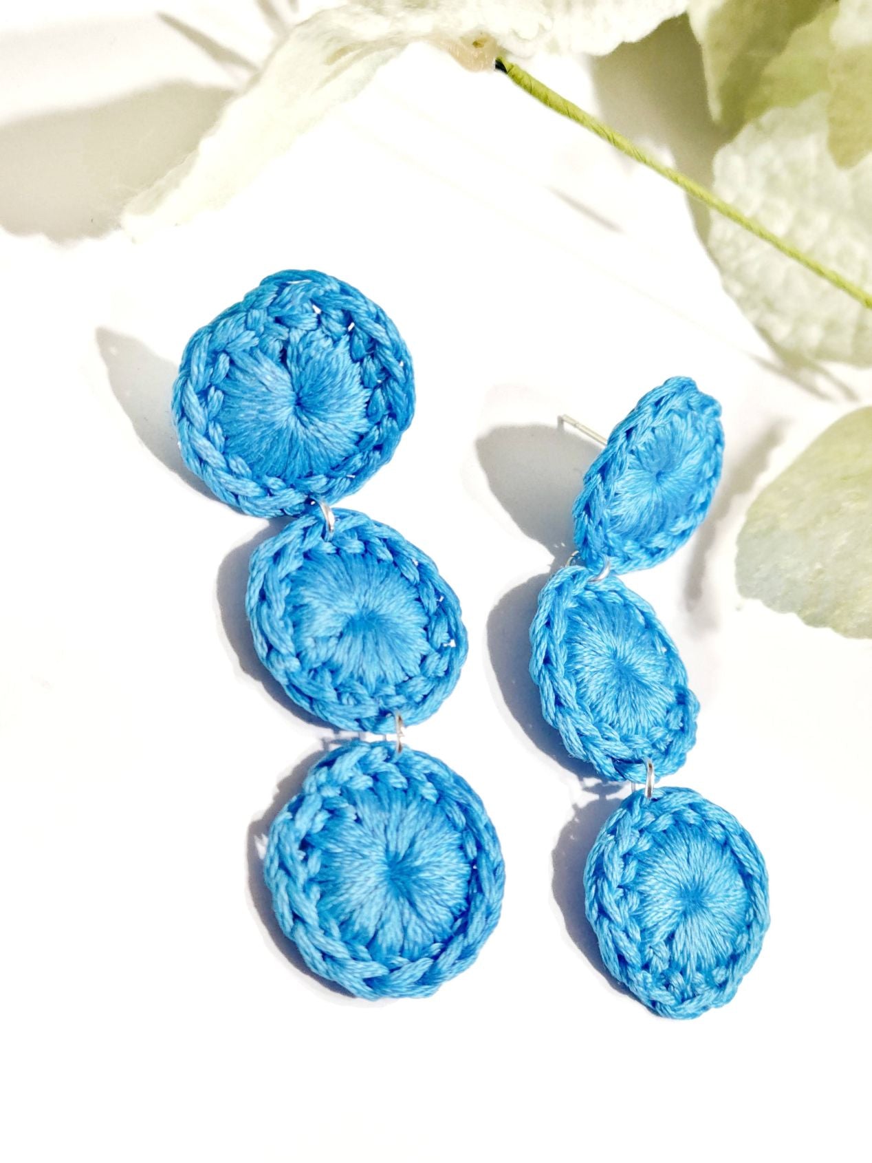 Close look at a pair of spring baby blue triple circle dangle earrings.