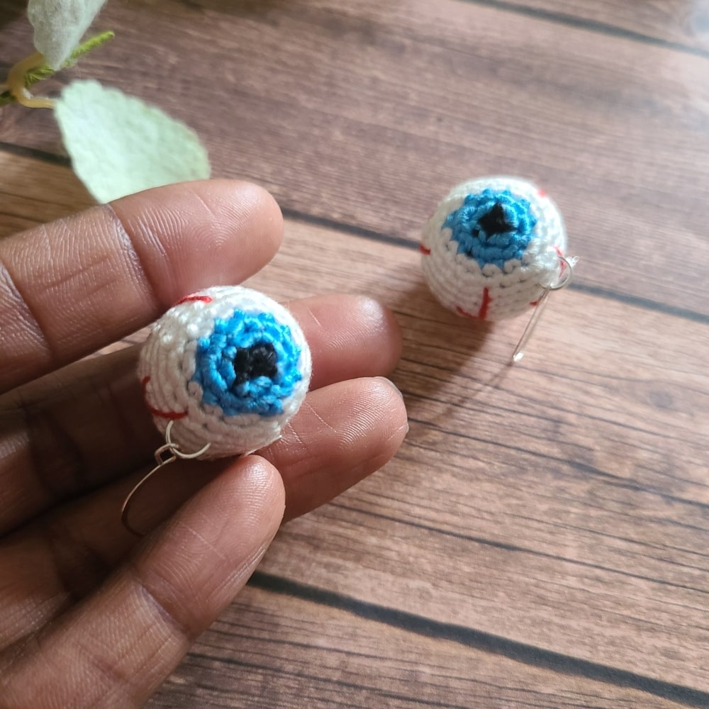 Eye ball earrings that are baby blue in color.