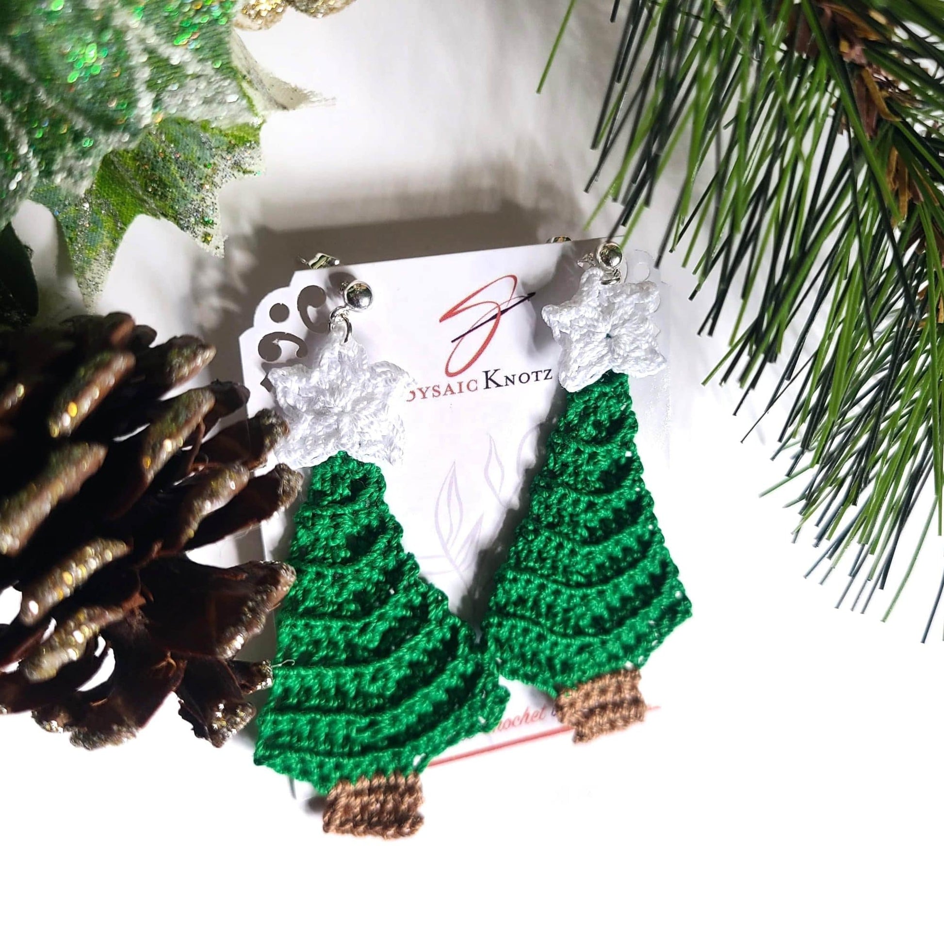 Christmas tree earrings on white background.