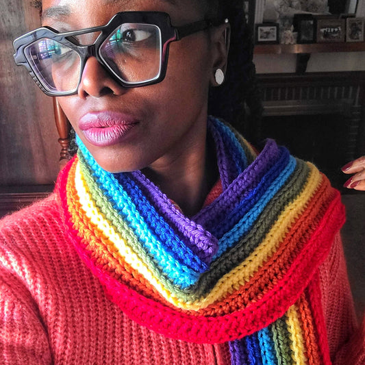 Ribbed rainbow scarf on model that is a bold winter accessory.