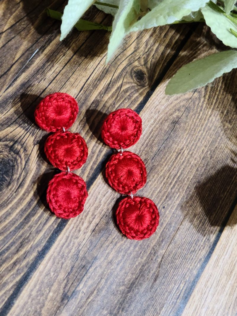 Red pair of triple circle dangle earrings.