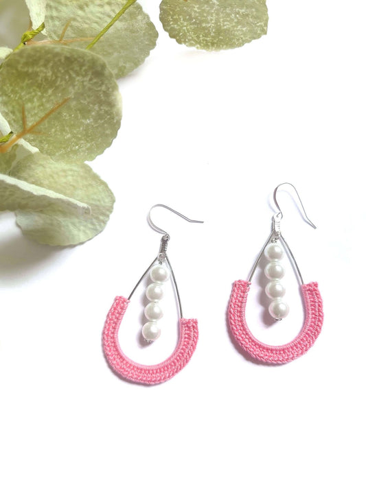 Pink dangle pearl earrings.