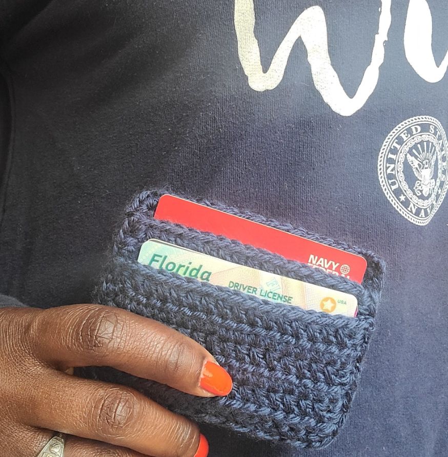 A model holding onto a 2 pocket wallet.