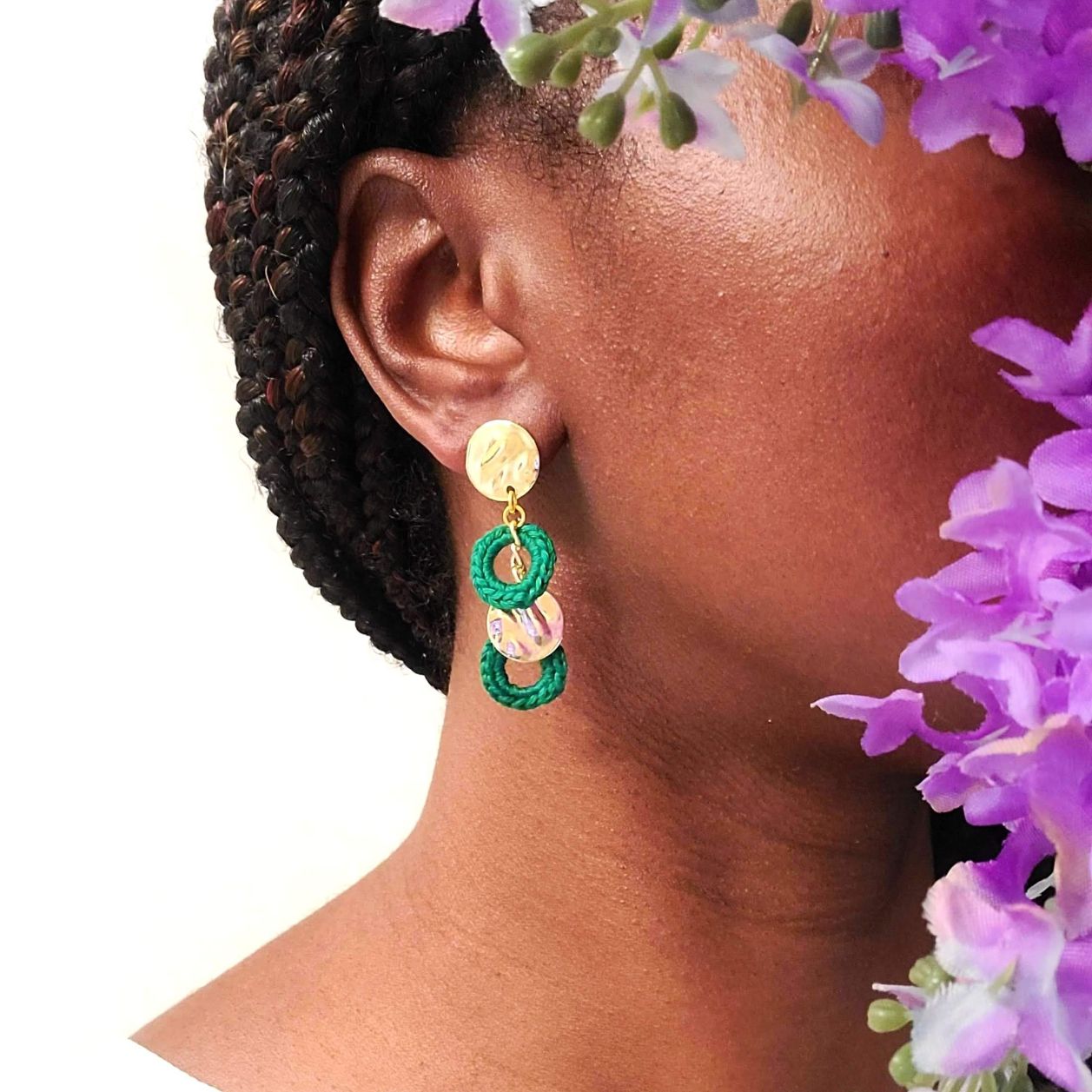 Model wearing a pair of circle and gold earrings.