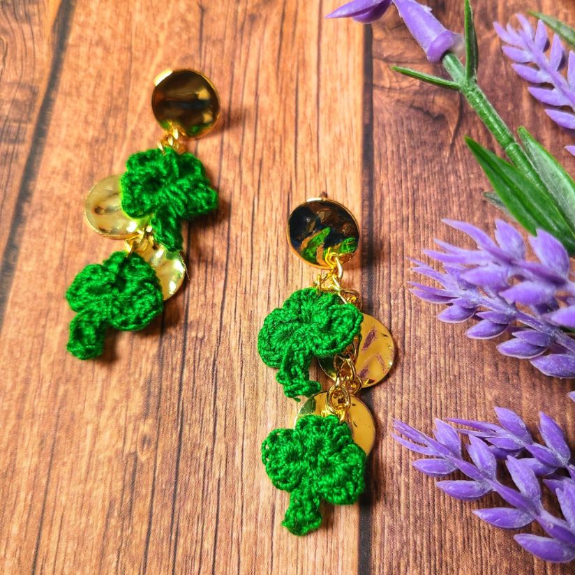 A close up of dangle shamrock earrings.