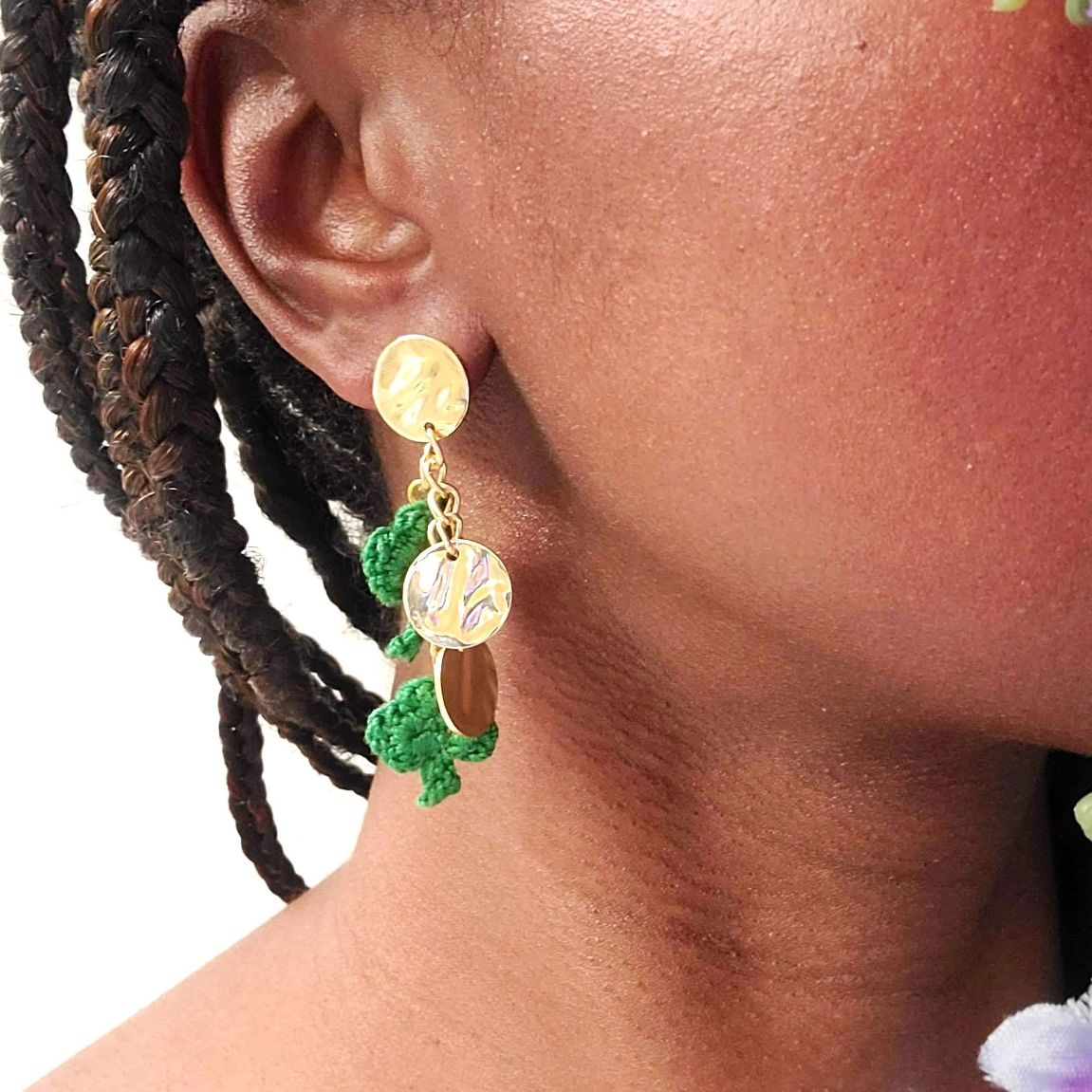 Model wearing trail of shamrock earrings.